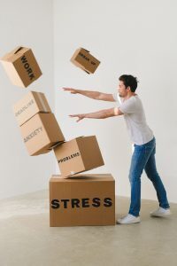 person knocking boxes that symbolize stress, problems, etc