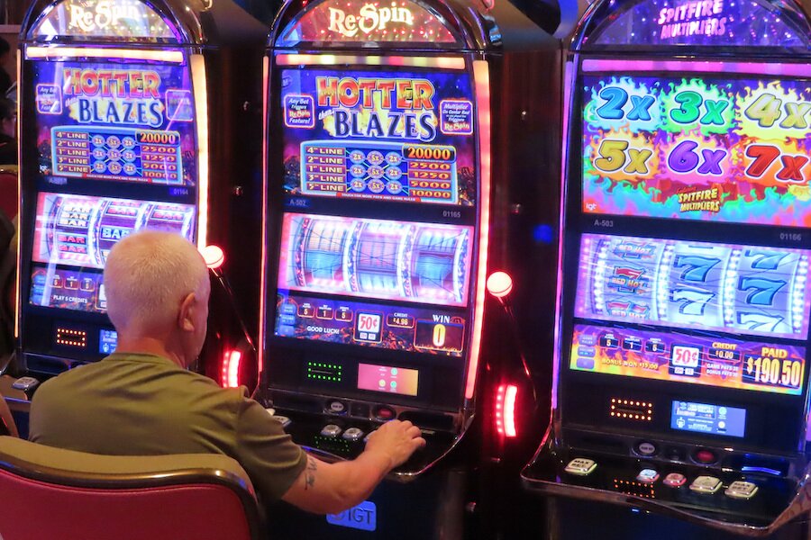 Man plays pokie machines in a casino